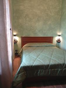 a bedroom with a bed with two lights on the wall at TABERNA ROMANA VILLA OCA b&b in Velletri