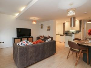 a living room with a couch and a table at 32A Bank Street in Rossendale +9 photos