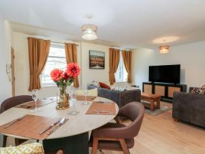 a dining room with a table and a living room at 32A Bank Street in Rossendale