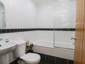 a white bathroom with a toilet and a sink at 32A Bank Street in Rossendale