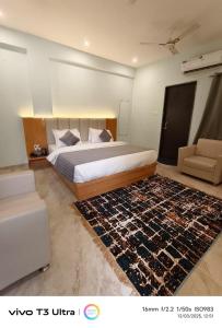 um quarto com uma cama grande e um tapete em Vilaasitaa Family Suites em Indore