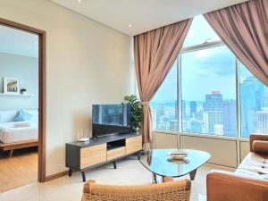 a living room with a tv and large windows at Sky Suite KLCC By SkyLights in Kuala Lumpur