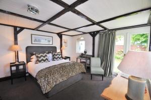 a bedroom with a bed and a desk with a chair at Cary Arms & Spa in Torquay