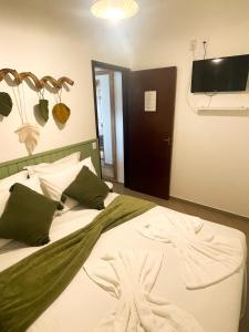 a bedroom with a bed and a tv on the wall at Moradas da Bibi in Guarda do Embaú