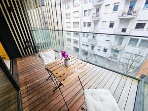 Cosy Terrace Studio close to city center-Limp11 في لوكسمبورغ: شرفة على طاولة وكراسي خشبية في مبنى +12 صورة