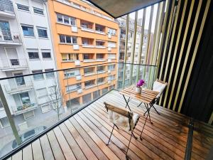 Cosy Terrace Studio close to city center-Limp11 في لوكسمبورغ: شرفة ذات سطح خشبي مع طاولة وكرسي