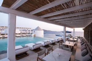 a resort with a pool and chairs and the ocean at Porto Mykonos in Mikonos