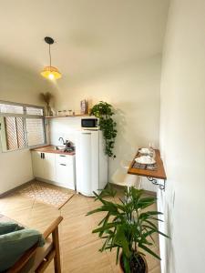 a kitchen with a table and a plant in a room at Moradas da Bibi in Guarda do Embaú +21 photos