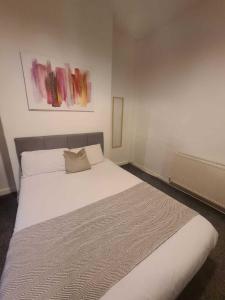 Un dormitorio con una gran cama blanca. en Two bedroom close to city, en Sunderland