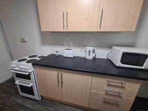 una cocina con estufa y microondas en Two bedroom close to city, en Sunderland
