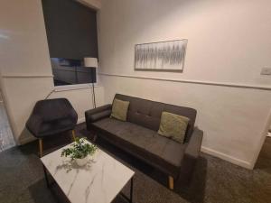 una sala de estar con un sofá y una silla en Two bedroom close to city, en Sunderland