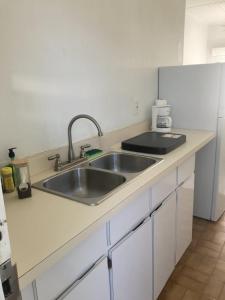 een keuken met een spoelbak en een aanrechtblad bij Queen Deluxe Double at Boundless Bliss Hotel in Raphune