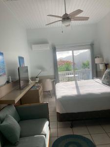 een slaapkamer met een bed, een bank en een raam bij Queen Deluxe Double at Boundless Bliss Hotel in Raphune