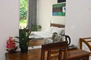 a bedroom with a bed and a table and a mirror at Savendro Villa Hikkaduwa in Hikkaduwa