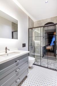 ein Badezimmer mit Dusche, Waschbecken und Toilette in der Unterkunft Spectacular sea views Villa with pool in Eskiömerler
