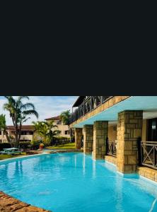 Una gran piscina azul al lado de un edificio en Ocean View Villas B09, en Port Edward