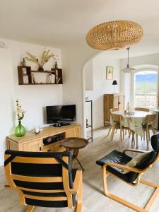 a living room with a table and a dining room at L'insouciance, a cottage in Provence in La Celle-sous-Gouzon