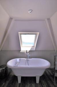 a white bath tub in a room with a window at Cary Arms & Spa in Torquay