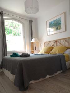 L'insouciance, a cottage in Provence في La Celle-sous-Gouzon: غرفة نوم بسرير ومخدات صفراء ونافذة