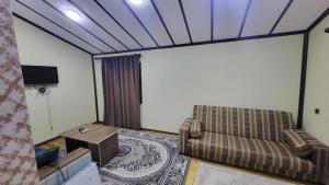 un soggiorno con un divano e un tavolo di Hotel Yaşıl Park a Mekhrably