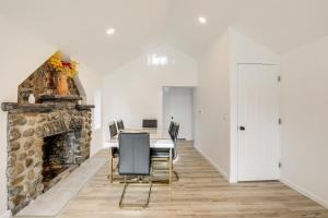 a dining room with a stone fireplace and a table and chairs at Home with Lake Views and Deck in New Jersey Highlands! in Stanhope