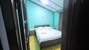 una piccola camera da letto con un letto con lenzuola e cuscini bianchi di Hotel Yaşıl Park a Mekhrably