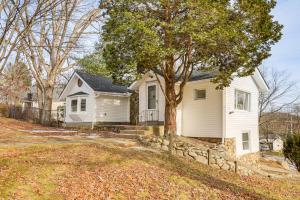 a white house with a tree in the yard at Home with Lake Views and Deck in New Jersey Highlands! in Stanhope