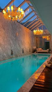 a pool in a house with a chandelier at Yoo Punta del este Deluxe in Punta del Este