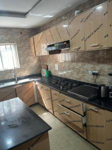 Egbeda vics guests house的配有木制橱柜和炉灶烤箱的厨房