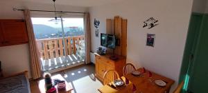 Vue panoramique - Confortable - Piscine - Randonnées - Skis في فون-رومو-أوديللو-فيا: غرفة معيشة مع طاولة وتلفزيون وشرفة
