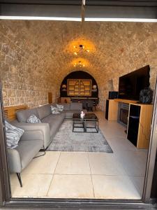 un soggiorno con un divano e un muro di mattoni di Ibiza a Batroûn