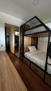 a bedroom with two bunk beds and a wooden floor at Hotel Laverdieri in Suba
