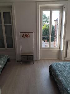 Duplex spacieux et lumineux en centre-ville في شاتودون: غرفة بيضاء بسريرين ونافذة