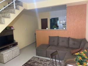 a living room with a couch and a staircase at Sabrina · Duplex com excelente localização, em Muriqui in Mangaratiba