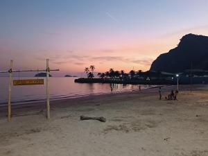 a group of people on a beach at sunset at Sabrina · Duplex com excelente localização, em Muriqui in Mangaratiba