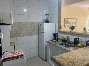 a kitchen with a white refrigerator and a sink at Sabrina · Duplex com excelente localização, em Muriqui in Mangaratiba
