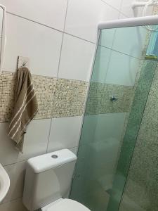 a bathroom with a toilet and a glass shower at Sabrina · Duplex com excelente localização, em Muriqui in Mangaratiba +6 photos