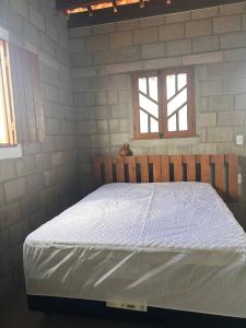 uma cama num quarto com 2 janelas em Raizes do bem estar em Lucena