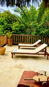 two lounge chairs and a bed on a patio at Eliza, Bangalô vista mar em Trancoso in Trancoso