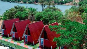 a row of red huts next to a river at Chalés Portal das Chácaras in Brejo Sêco