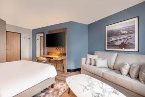 ロワシー・アン・フランスにあるGolden Tulip CDG Airport Roissyのベッドとソファのあるリビングルーム