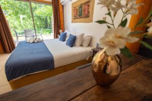 San Francisco Lodge في لوس أوديس: غرفة نوم مع سرير و مزهرية مع الزهور +90 صورة