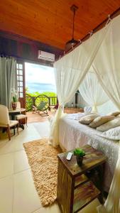 a bedroom with a bed with a view of the ocean at Bangalô Maria Vista Mar, Luxo em Trancoso in Porto Seguro