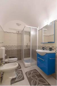 a bathroom with a toilet and a sink and a shower at Casa Red & Blue in Castellammare del Golfo