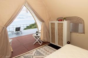 Un dormitorio con una tienda de campaña con vista al mar. en A Slice of Paradise, en Tapantí