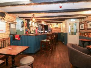 een bar met houten tafels en stoelen in een restaurant bij Bedroom 2 in Wolsingham