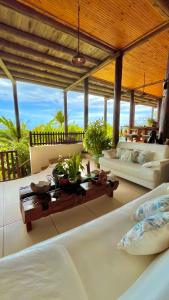 a living room with a large bed and a table at Bangalô Maria Vista Mar, Luxo em Trancoso in Porto Seguro +32 photos