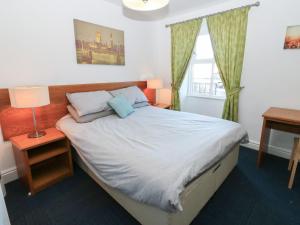 een slaapkamer met een bed, een bureau en een raam bij Bedroom 2 in Wolsingham