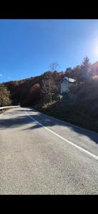 an empty road with a house on the side of a hill at Vikendica Iris in Mojkovac