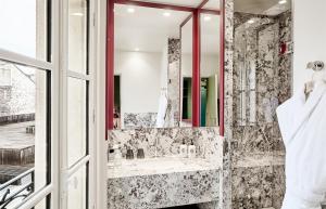 a bathroom with a sink and a mirror at Hôtel Prince de Conti - Hôtel Rénové in Paris +57 photos